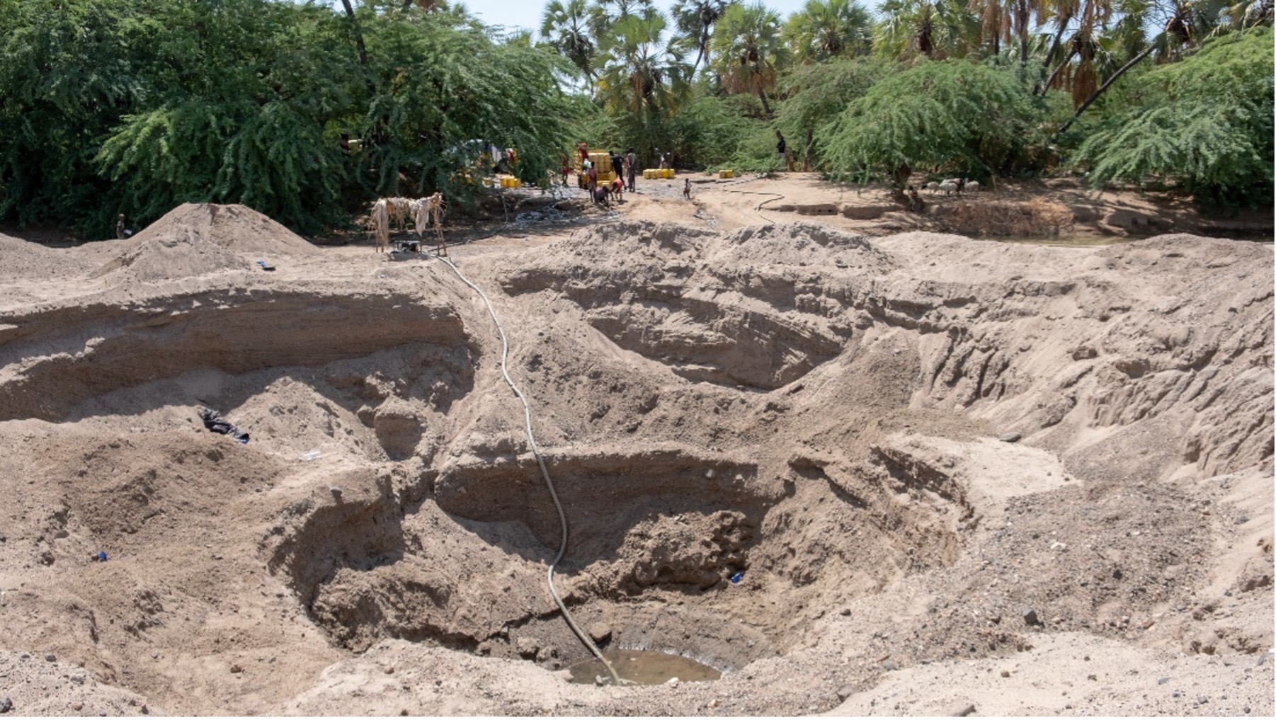 Water vendors fetching water from a dip shallow well near Kalokol town