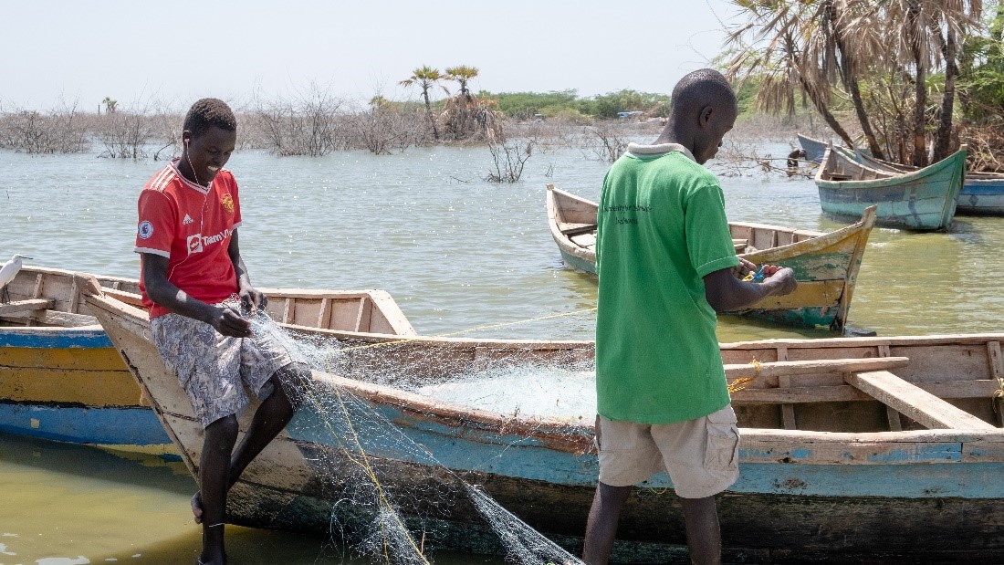 Kenya - Two fishermen preparing their nets before going out to fish in Impresa beach in Kalokol town