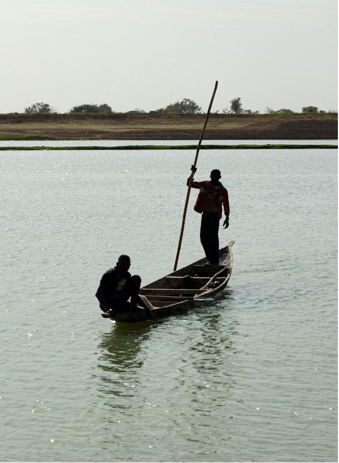 Pinasse boatmen navigating on the Niger river