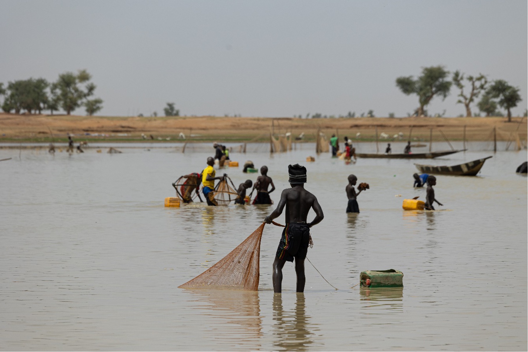 Des enfants apprenant à pêcher les poissons dans le fleuve en période de décrue